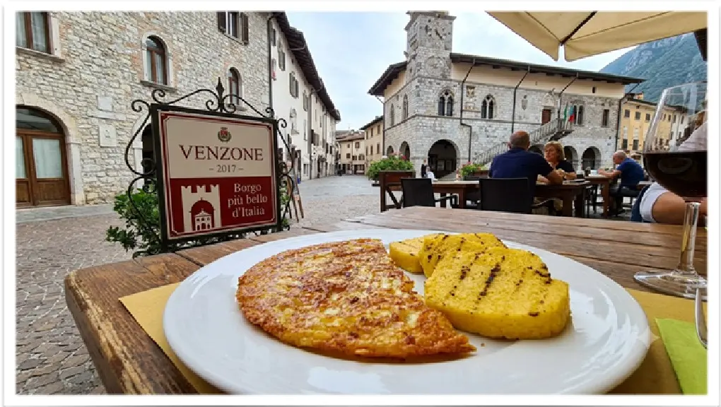 Piatto tradizionale friulano con Frico croccante di formaggio Montasio e patate, servito con polenta fumante.